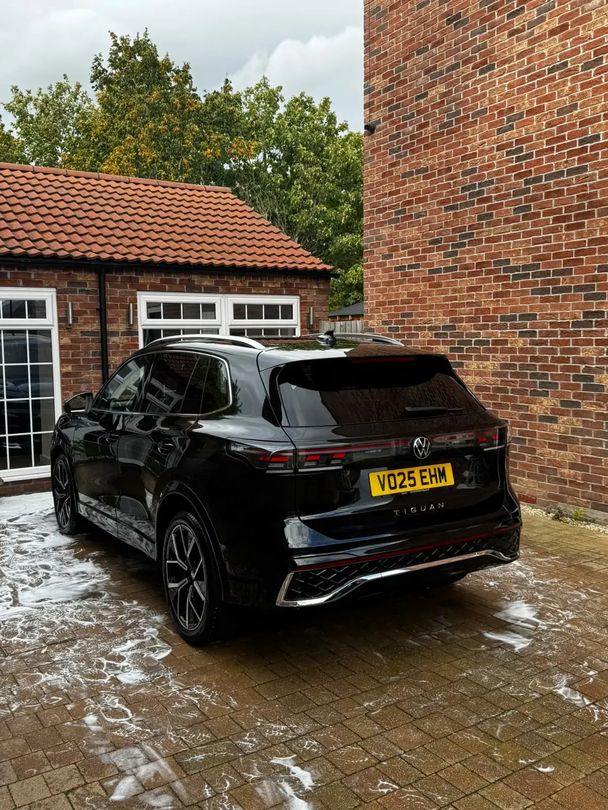 Black Volkswagen Tiguan R-Line gleaming on a block-paved drive after a clean inside and out